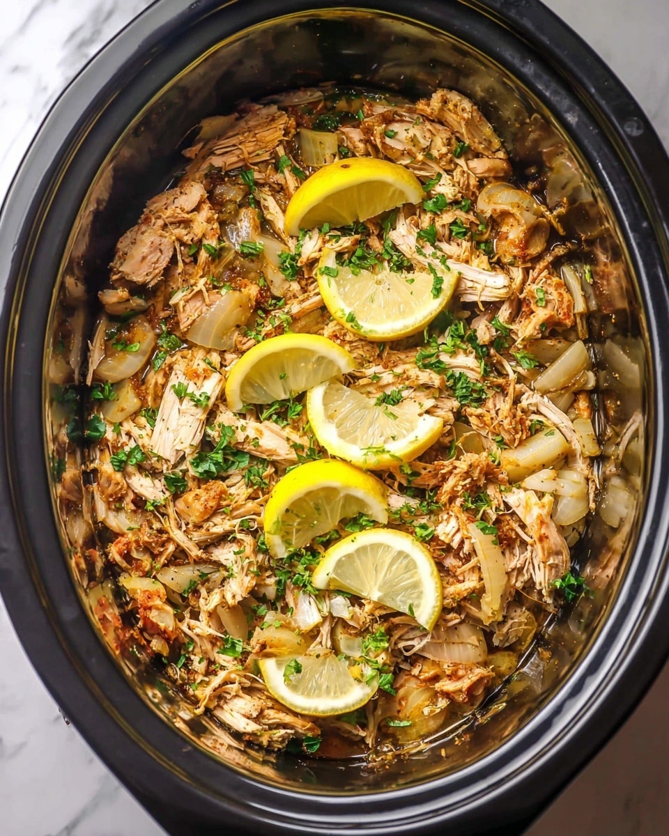 This image shows a slow cooker filled with three main layers: the bottom layer is tender shredded chicken with brown and white tones, spread evenly; the middle layer consists of cooked translucent onion slices scattered across the chicken; the top layer has bright green chopped herbs sprinkled over everything and three lemon wedges placed on top for decoration. The slow cooker sits on a white marbled surface. Photo taken with an iphone --ar 4:5 --v 7