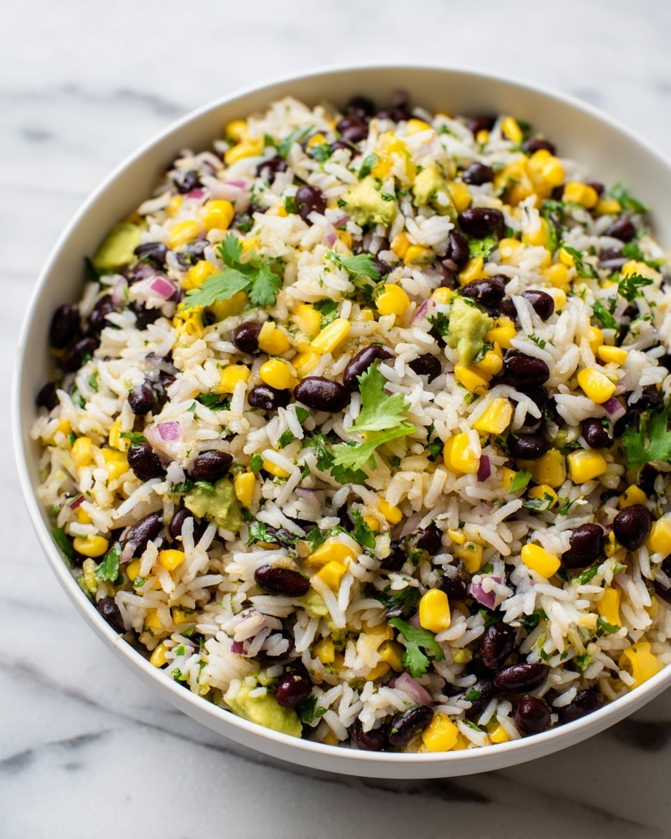 A close-up view of a bowl filled with a rice salad showing three main layers mixed together: fluffy white rice with a slightly glossy texture, black beans adding dark round shapes scattered evenly, and bright yellow corn kernels providing a pop of color throughout. Small pieces of green avocado are spread inside, with bits of finely chopped red onion and green herbs adding extra color and texture. The bowl is white, set on a white marbled surface, and fresh cilantro leaves are placed on one side inside the bowl. photo taken with an iphone --ar 4:5 --v 7