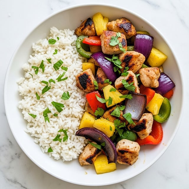 The dish is served in a white bowl placed on a white marbled surface. It has two main layers: on the left side, there is a fluffy layer of white rice topped with small green herb pieces, taking about one-third of the bowl. On the right side, the larger portion features grilled chicken chunks with a golden brown and slightly charred texture mixed with bright yellow pineapple cubes, thick slices of red and green bell peppers, and large pieces of cooked purple onion. The ingredients are evenly mixed, and fresh chopped herbs are sprinkled on top, adding a vibrant green contrast to the warm colors below. photo taken with an iphone --ar 4:5 --v 7