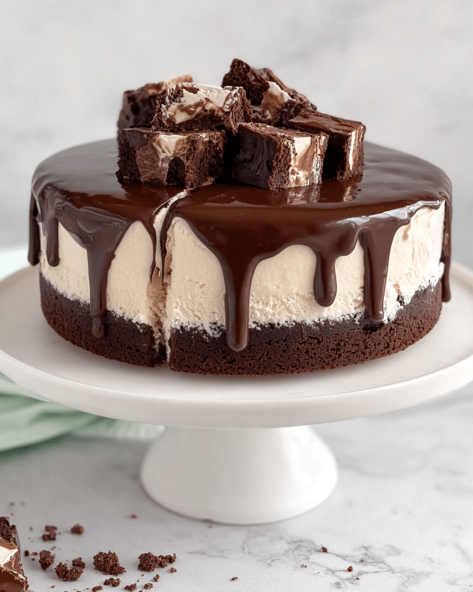 The image shows a round cake on a white cake stand with three visible layers: a dark brown chocolate cake bottom layer, a thick creamy white middle layer of ice cream or mousse, and another thin layer of dark chocolate cake mixed within the creamy layer near the base. The top is covered with a glossy, dark chocolate ganache that drips slightly over the sides. Small, square chunks of rich, dark chocolate brownie are piled on top, adding texture and height. The cake is set on a white marbled surface with some chocolate crumbs around the base. photo taken with an iphone --ar 4:5 --v 7