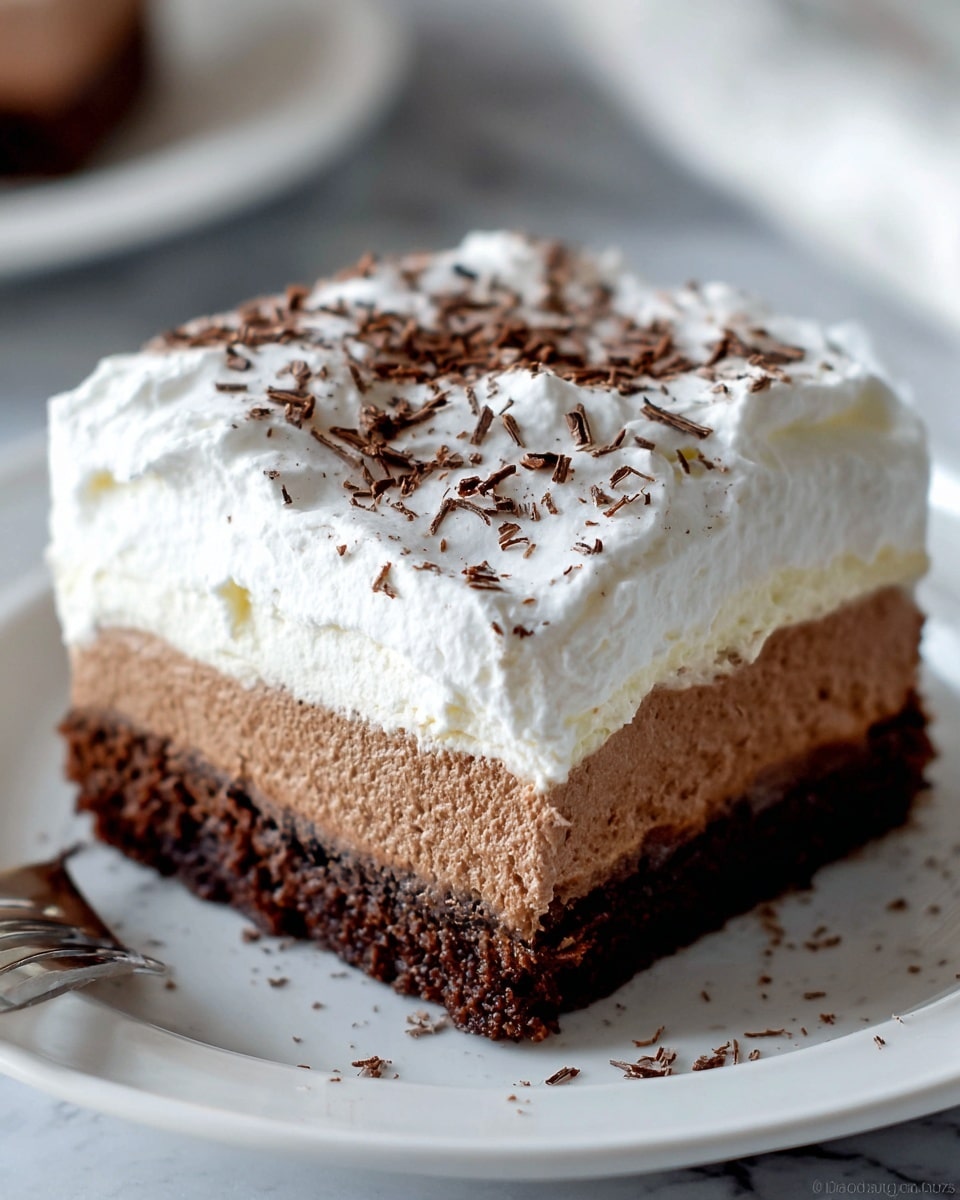 The image shows a dessert with three distinct layers on a white plate over a white marbled surface. The bottom layer is a dark brown, dense chocolate cake. The middle layer is a creamy, light brown chocolate mousse that looks smooth and thick. The top layer is a fluffy, white whipped cream spread unevenly with soft peaks and sprinkled with dark brown chocolate shavings. A silver fork rests beside the dessert on the plate. Photo taken with an iphone --ar 4:5 --v 7